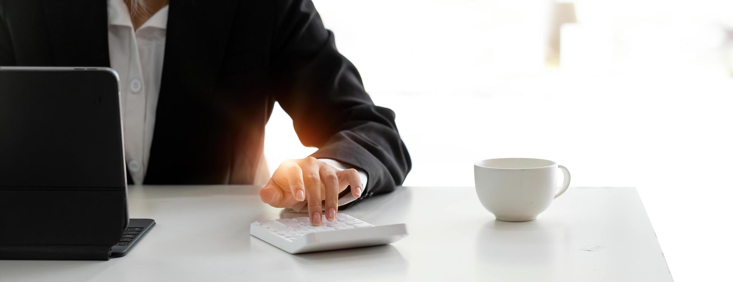 Close up Businessman using calculator and laptop for calaulating finance, tax, accounting, statistics and analytic research concept photo