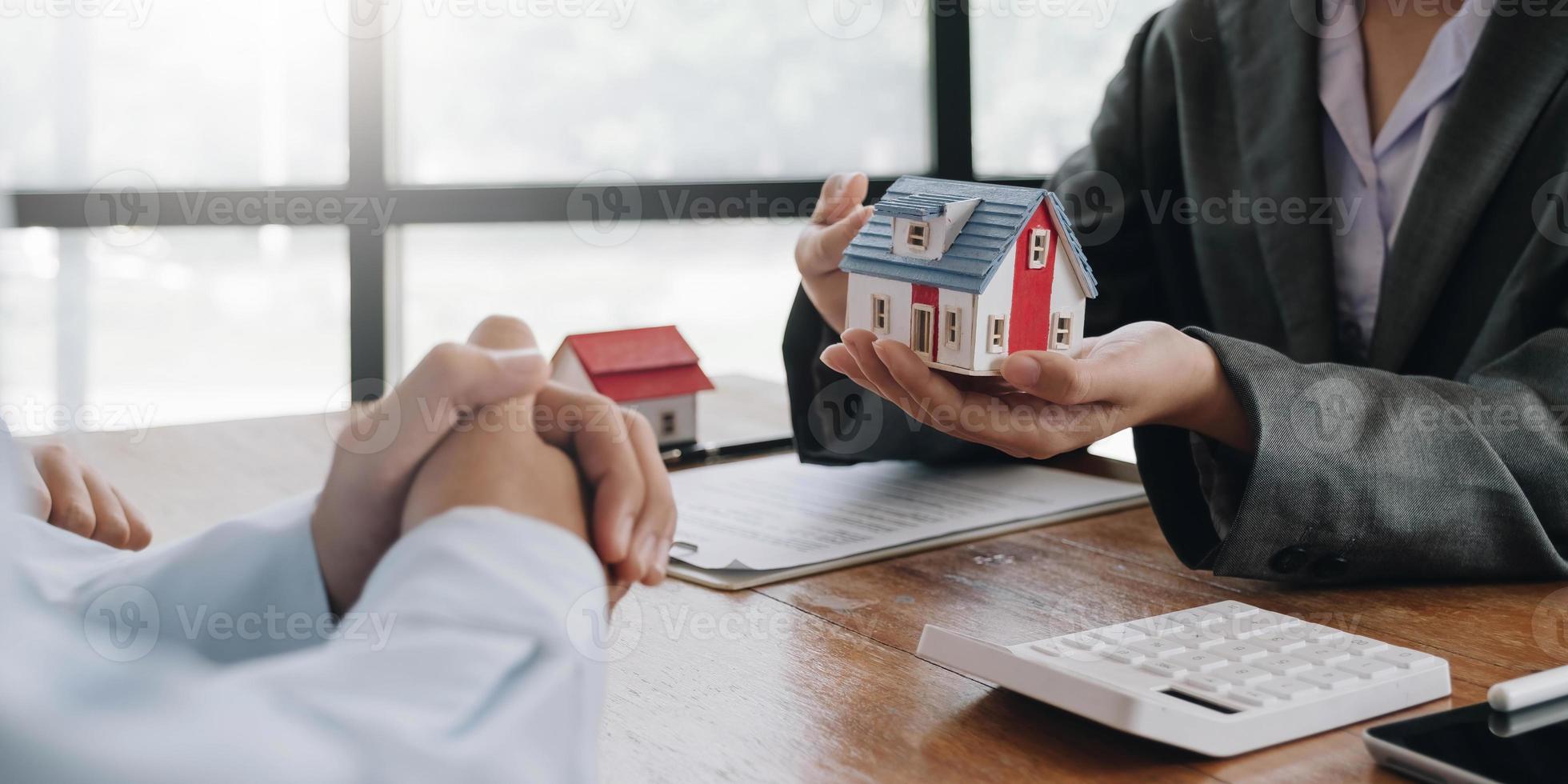 Real estate agent talked about the terms of the home purchase agreement and asked the customer to sign the documents to make the contract legally, Home sales and home insurance concept. photo