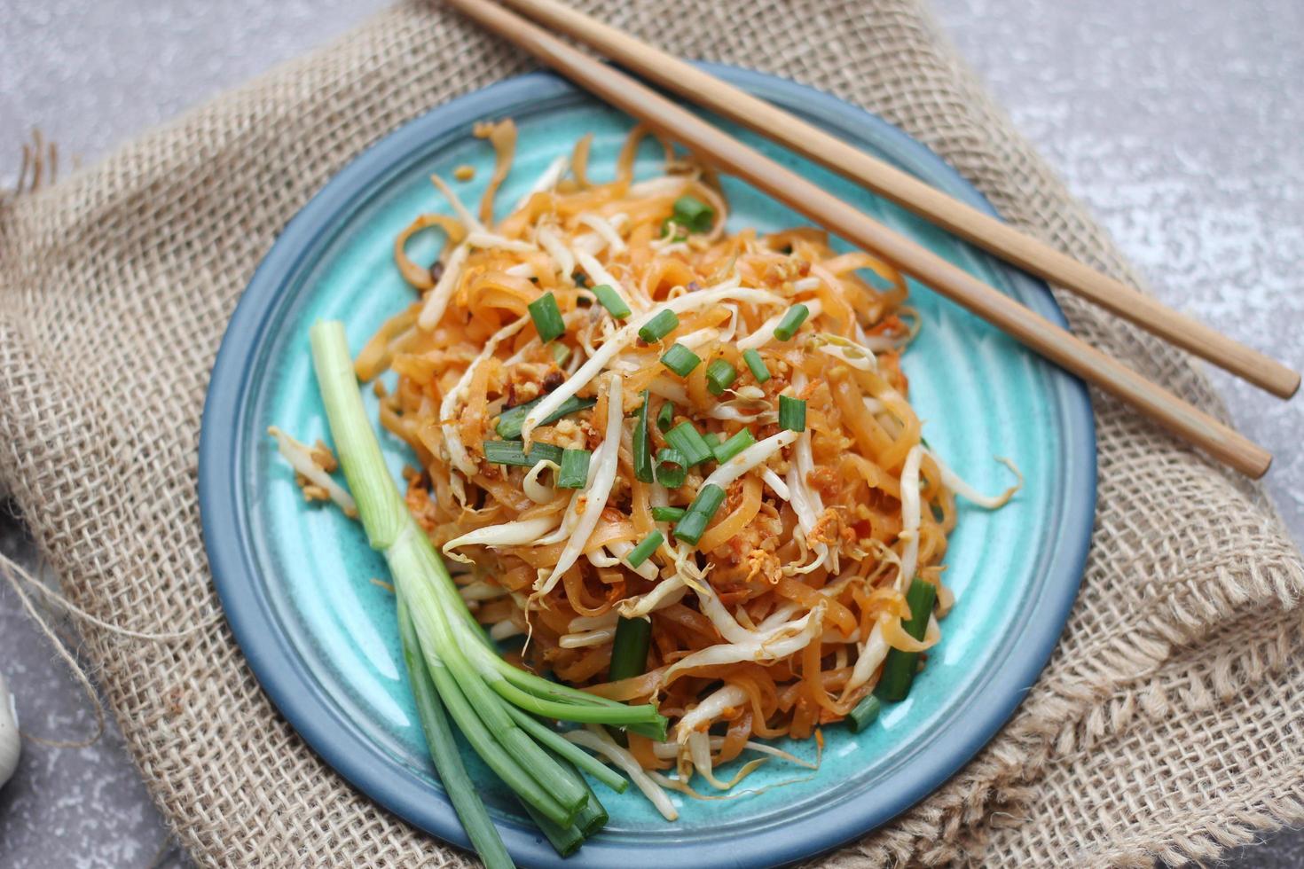 Thai food Pad Thai Thai stir-fried noodles national dish served in blue plate. photo