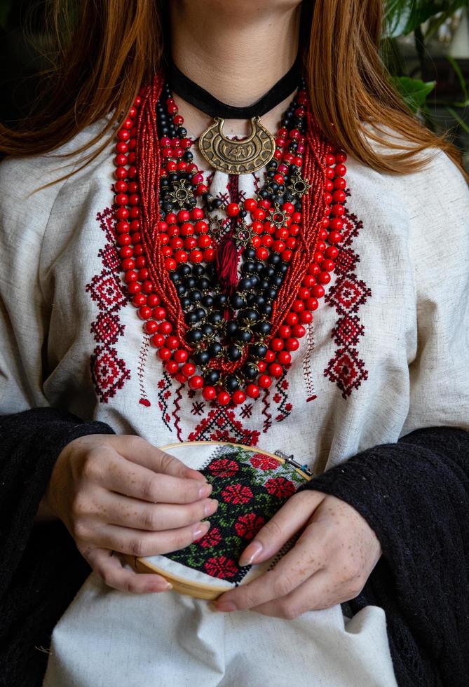 A girl embroiders a traditional Ukrainian vyshyvanka pattern photo