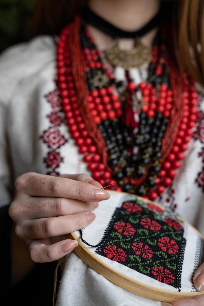 A girl embroiders a traditional Ukrainian vyshyvanka pattern photo