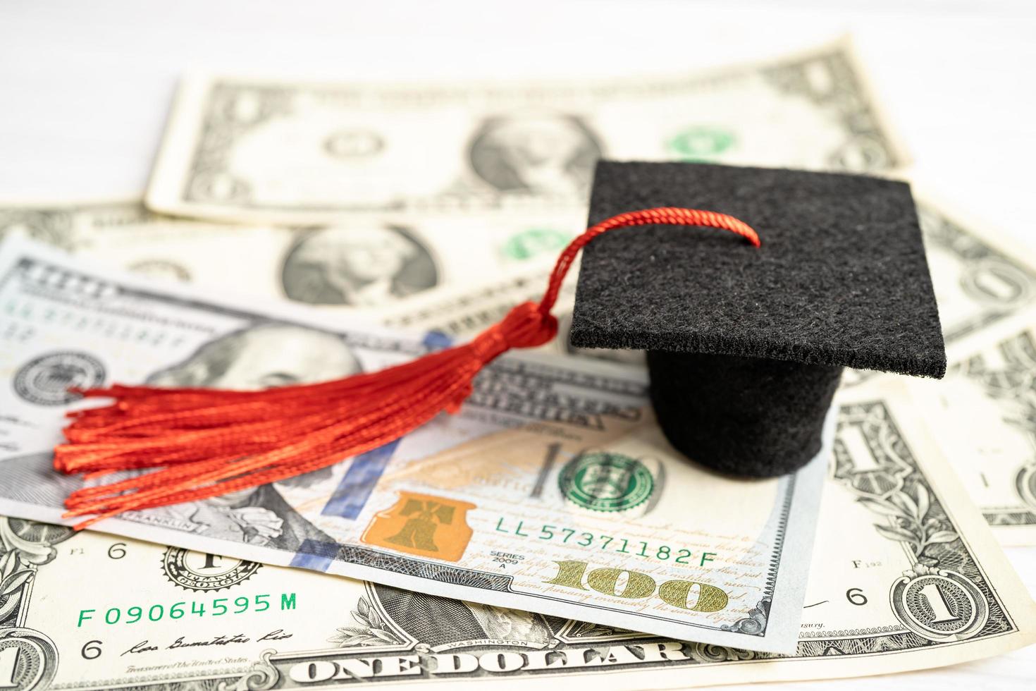 sombrero de la brecha de graduación en el dinero de los billetes en dólares estadounidenses, concepto de enseñanza de aprendizaje de la tarifa de estudio de educación. foto