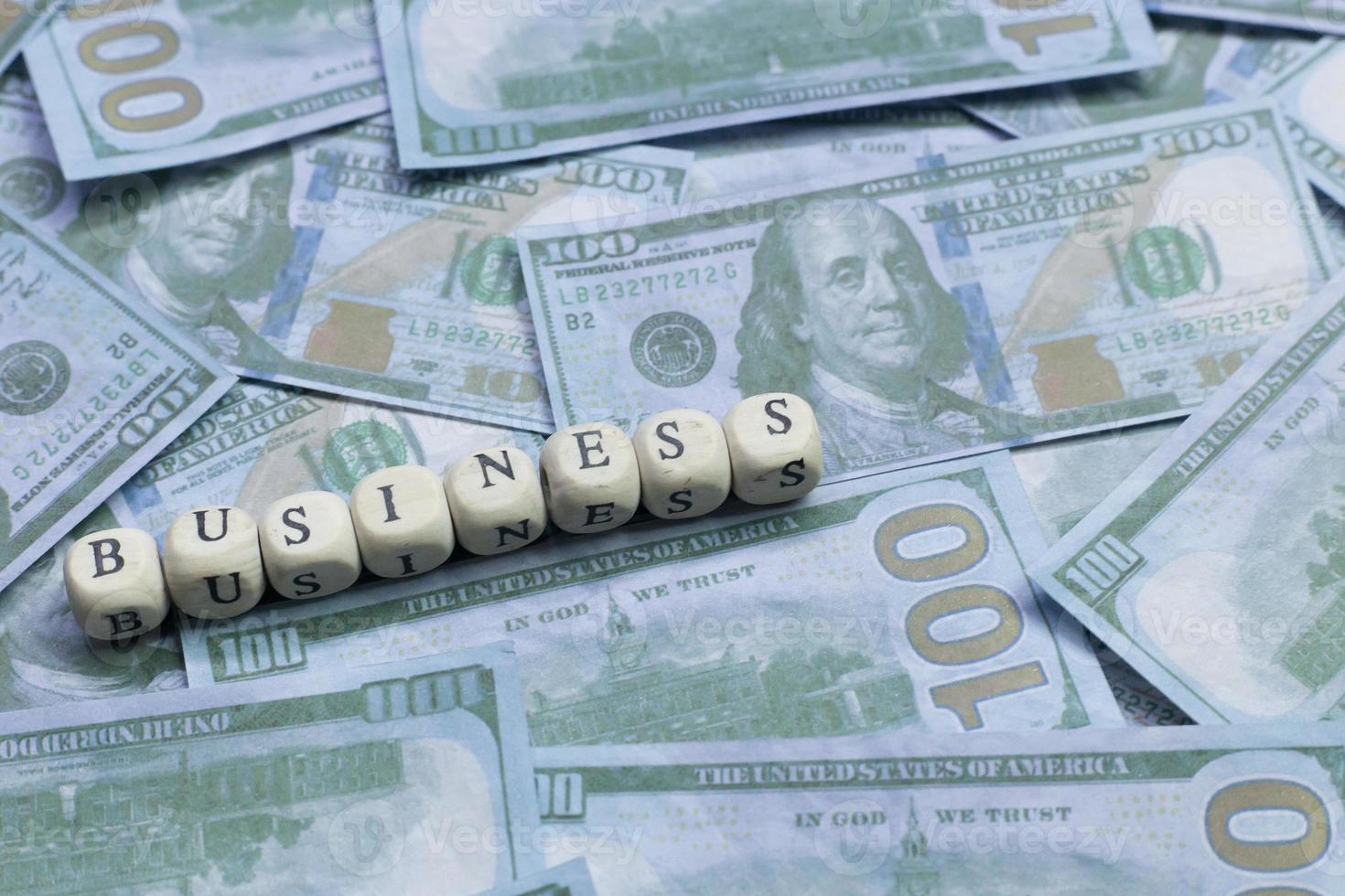 Business word on wood brick  background banknote. photo