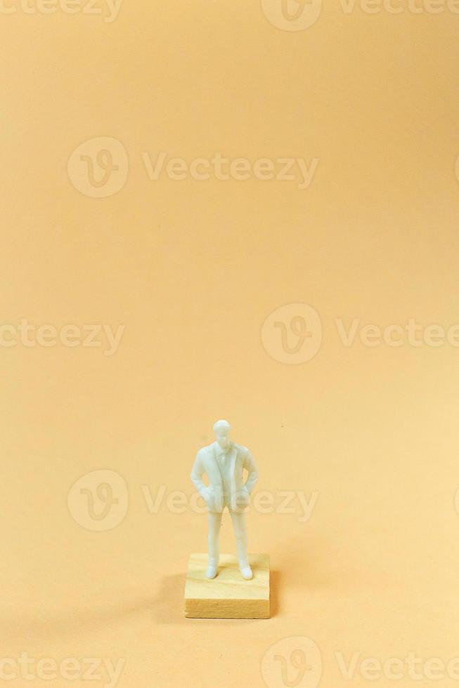 white  figure miniature on orange pastel for business content. photo