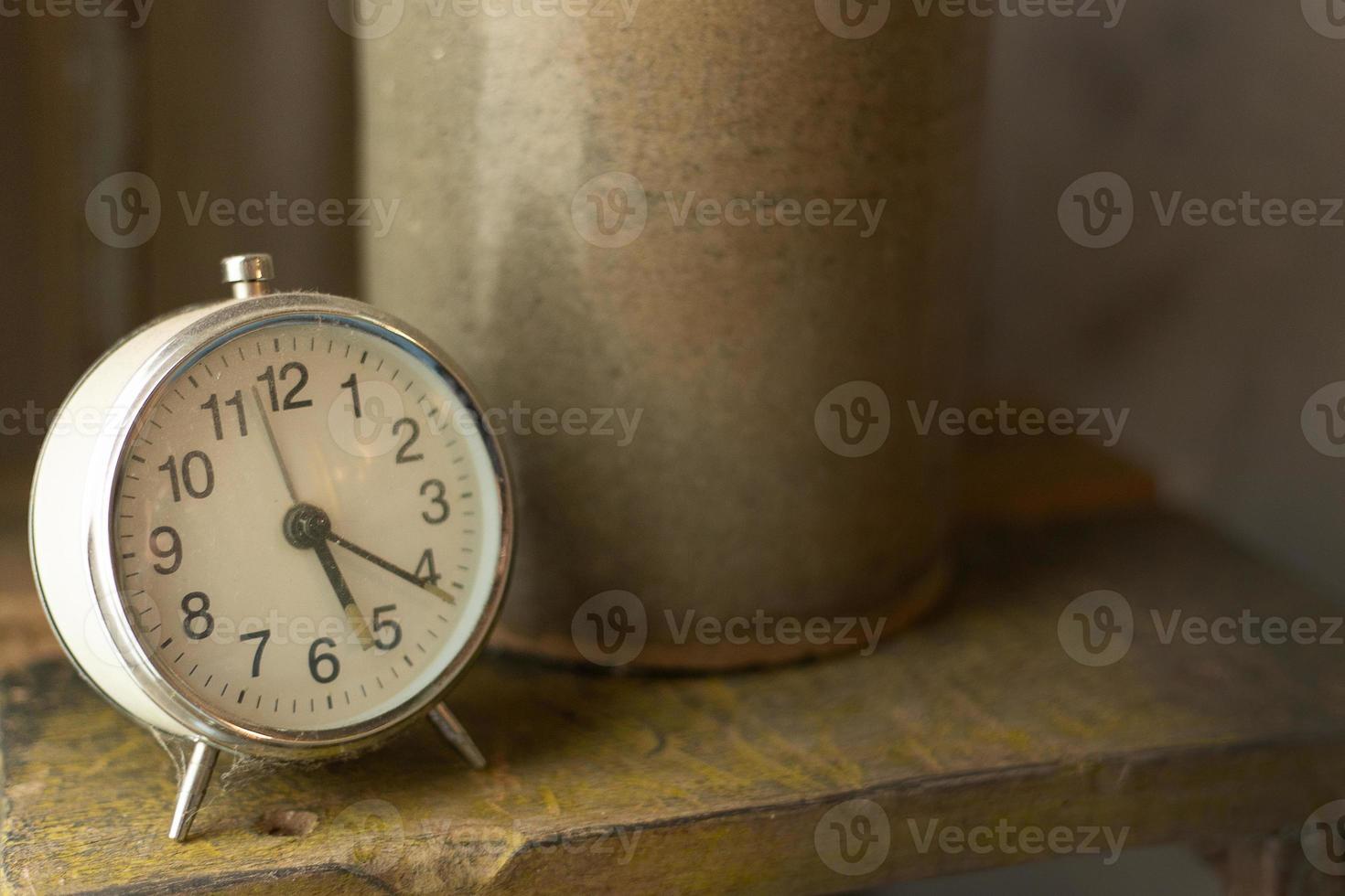 White vintage clock alarm  near window light. photo