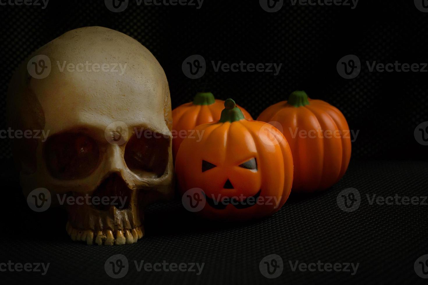 The halloween pumpkin jack and skull in black holiday background image. photo