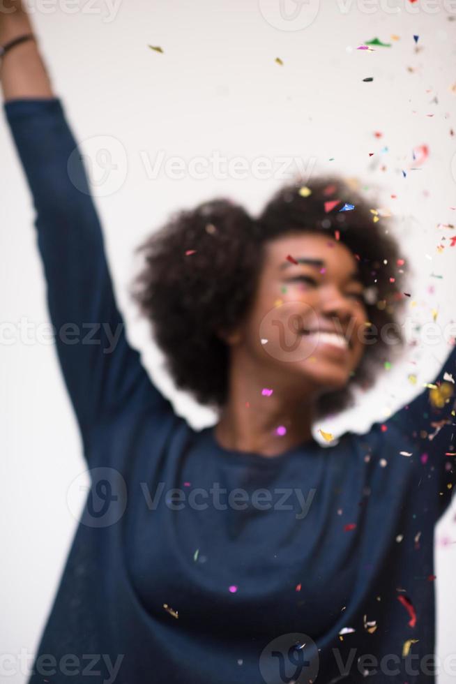 mujer afroamericana soplando confeti en el aire foto