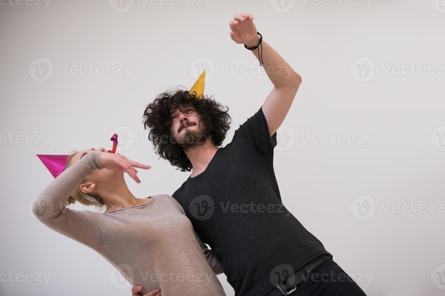 couple in party hats blowing in whistle photo