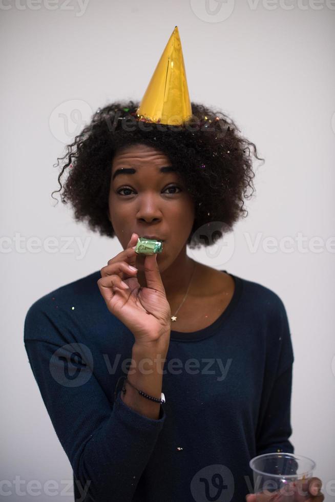 black woman in party hat blowing in whistle photo