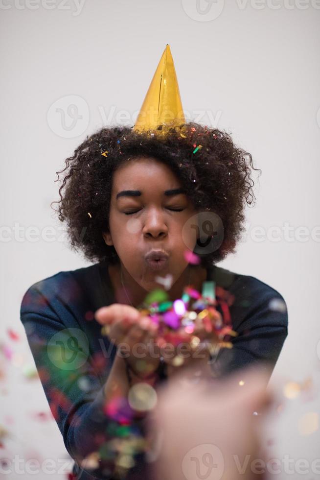 African American woman blowing confetti in the air photo