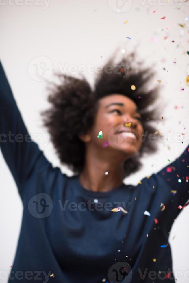 mujer afroamericana soplando confeti en el aire foto