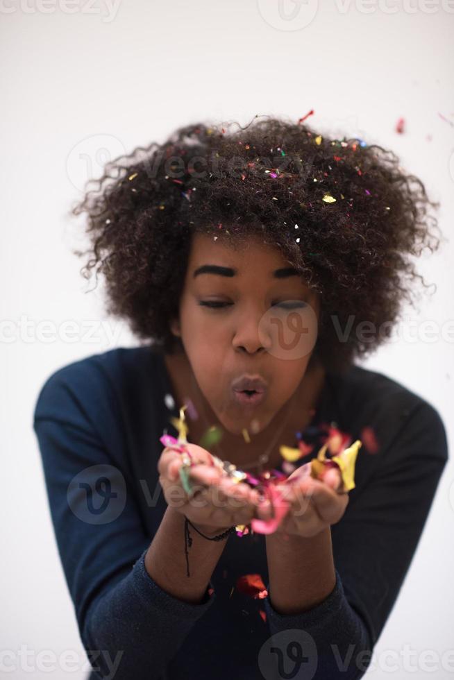 African American woman blowing confetti in the air photo