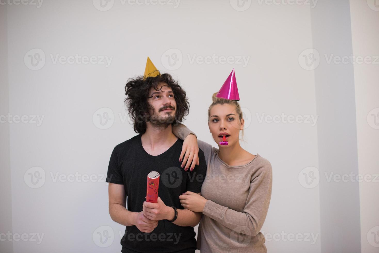 pareja en sombreros de fiesta soplando en silbato foto