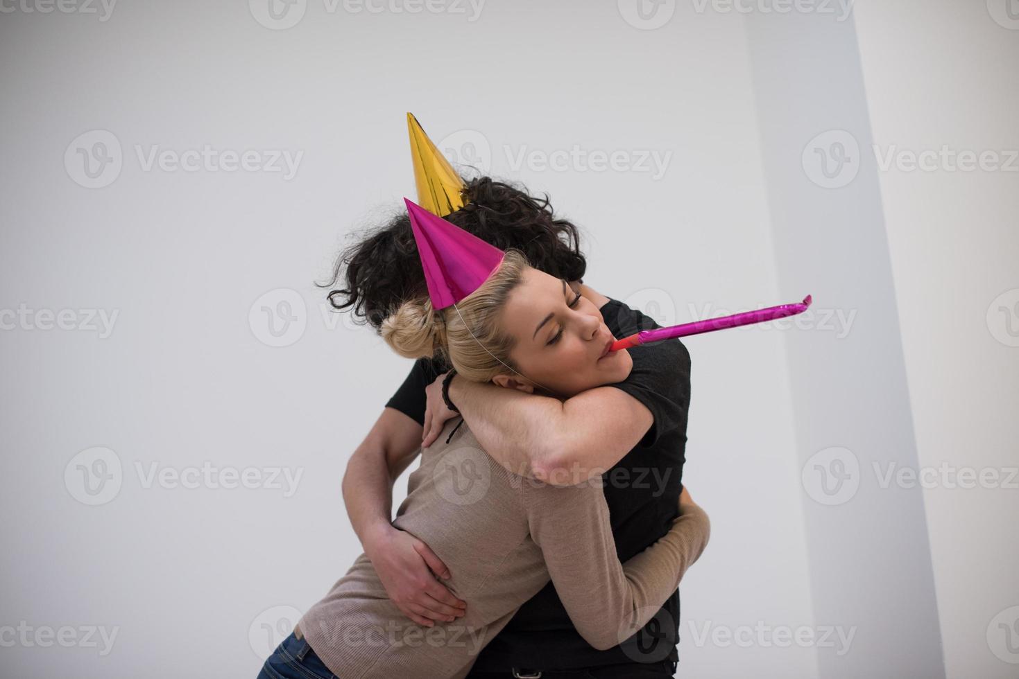 pareja en sombreros de fiesta soplando en silbato foto