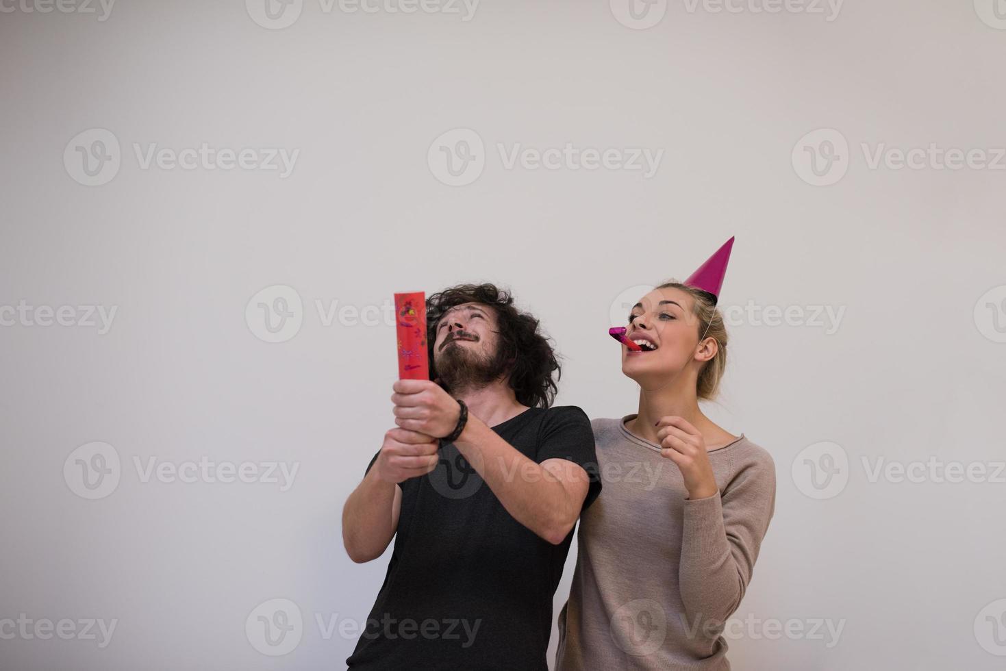 pareja en sombreros de fiesta soplando en silbato foto