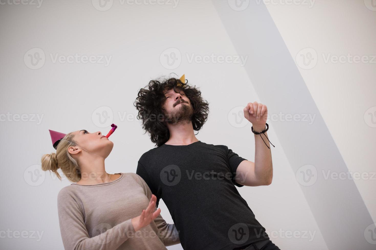 pareja en sombreros de fiesta soplando en silbato foto