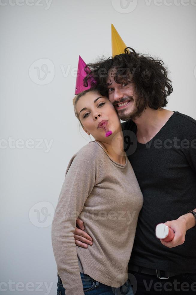 couple in party hats blowing in whistle photo