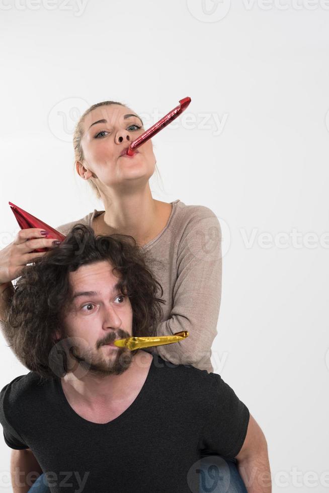 couple in party hats blowing in whistle photo