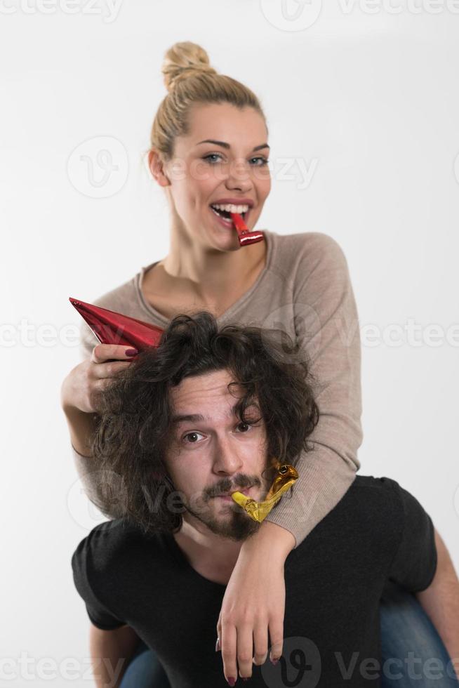 pareja en sombreros de fiesta soplando en silbato foto