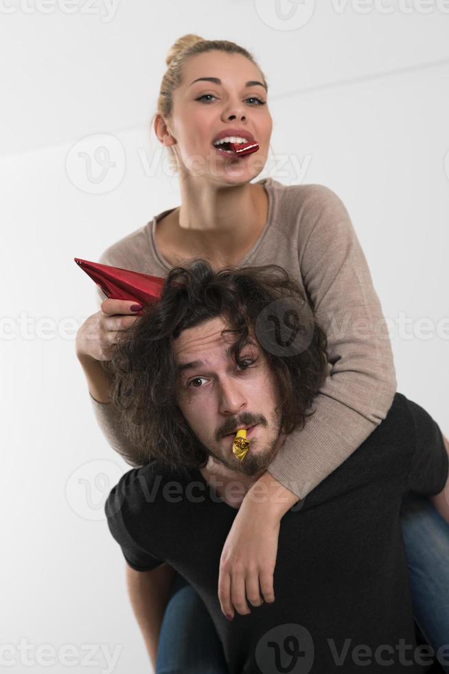 couple in party hats blowing in whistle photo