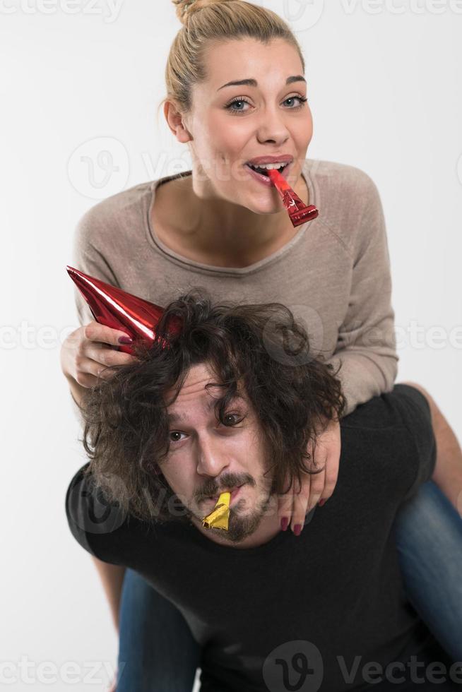 couple in party hats blowing in whistle photo