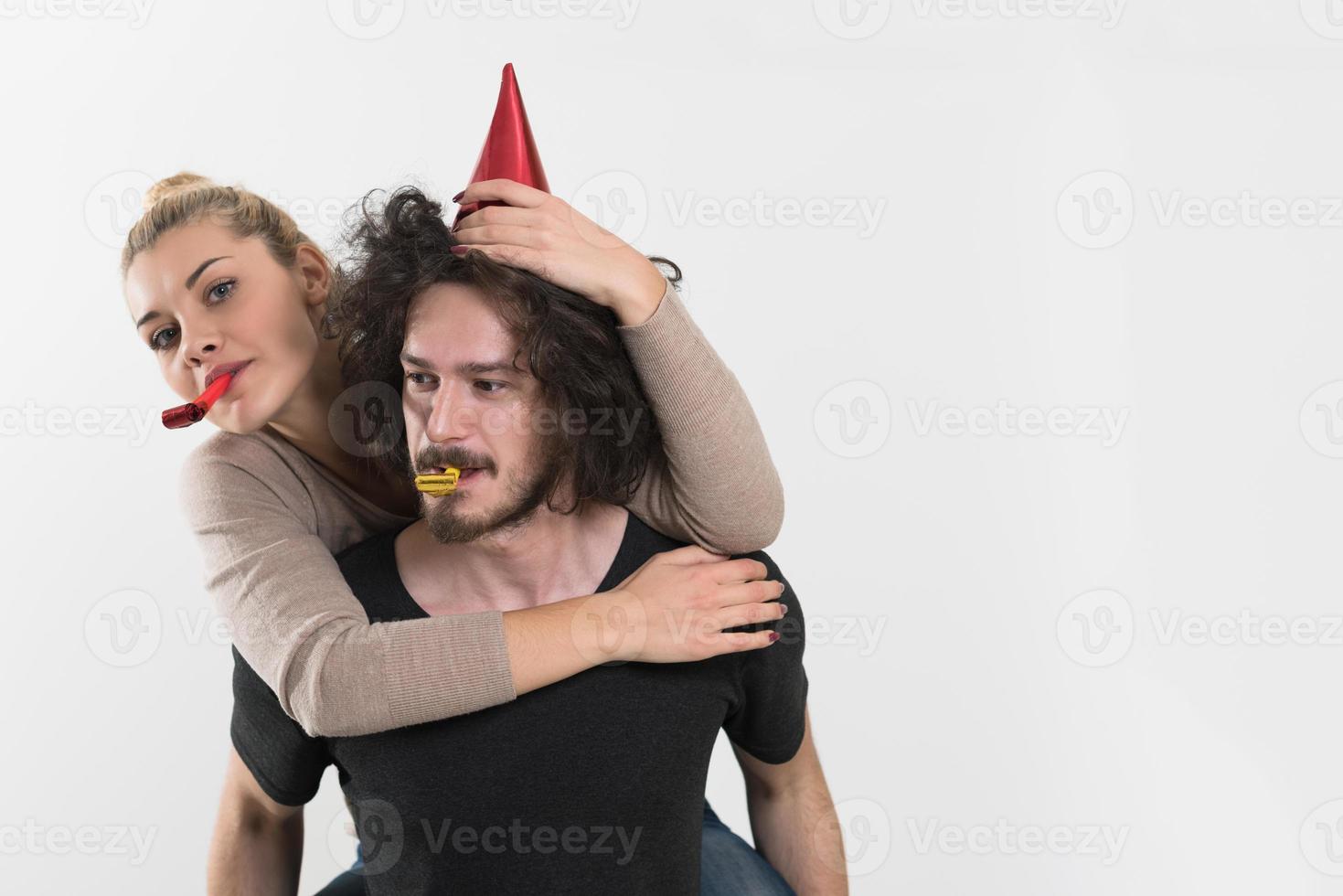 couple in party hats blowing in whistle photo