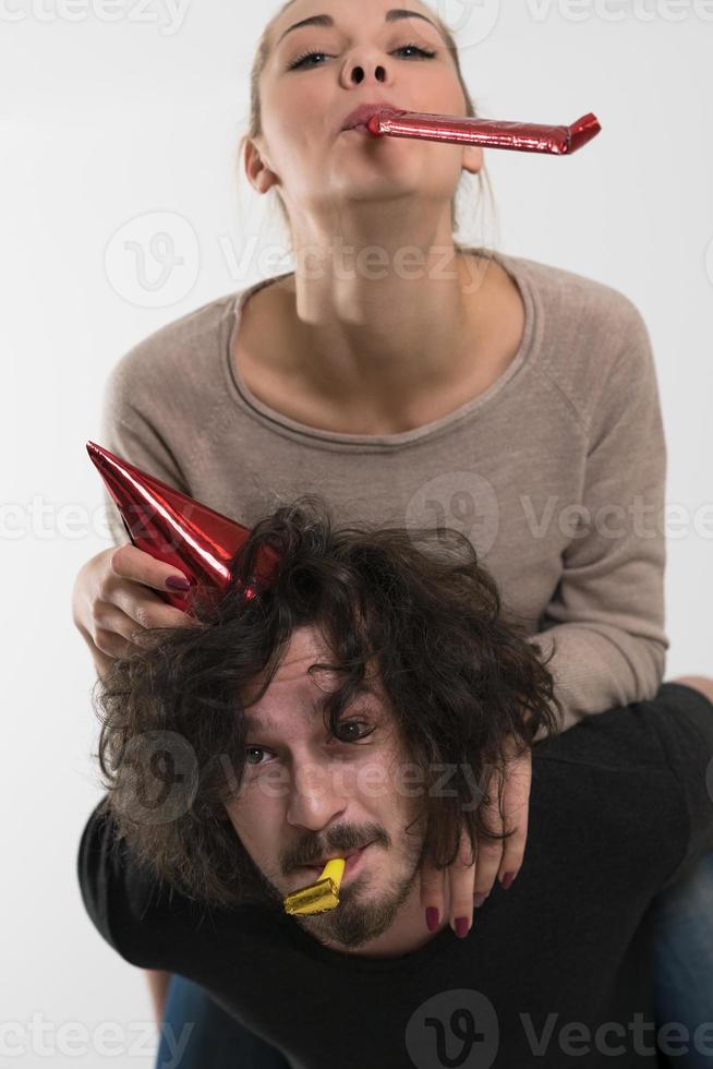 couple in party hats blowing in whistle photo