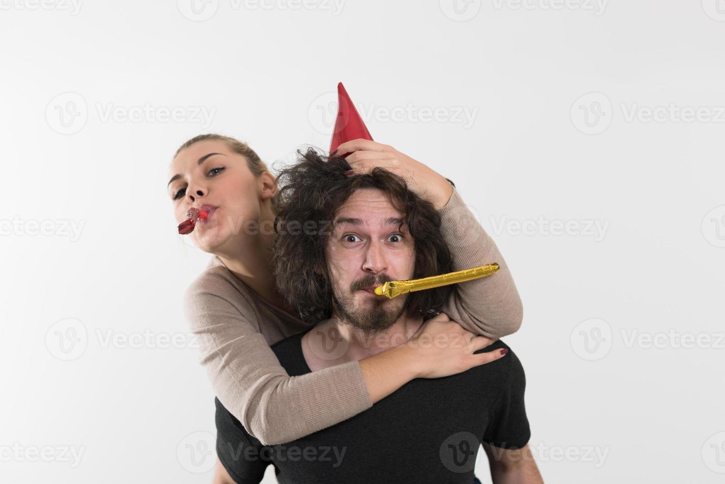 couple in party hats blowing in whistle photo