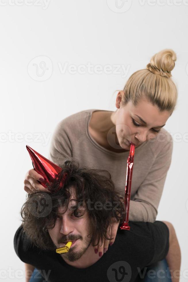 couple in party hats blowing in whistle photo