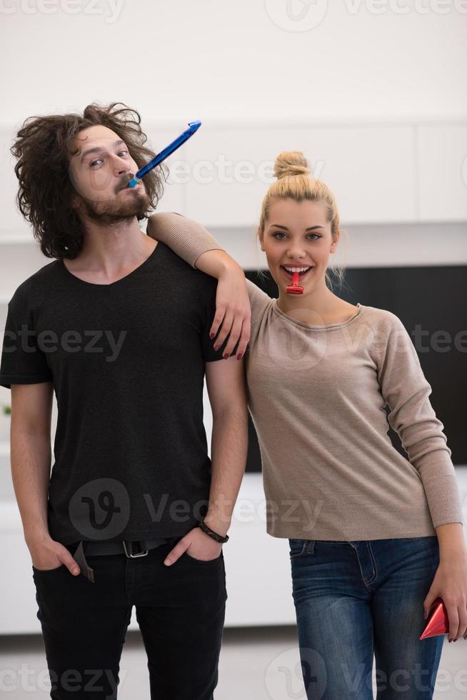 couple in party hats blowing in whistle photo