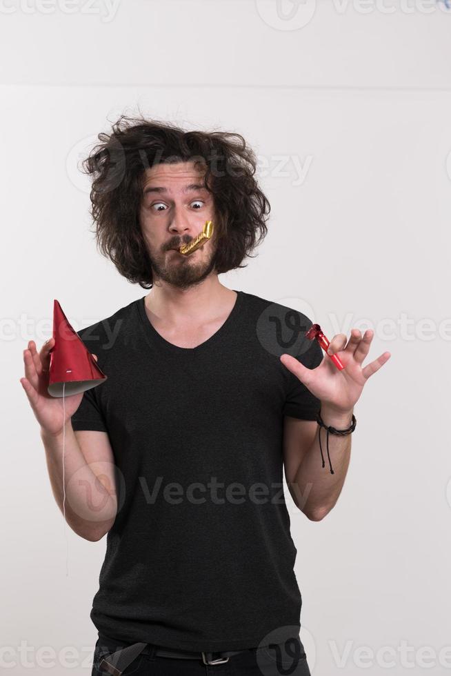 Portrait of a man in party hat blowing in whistle photo