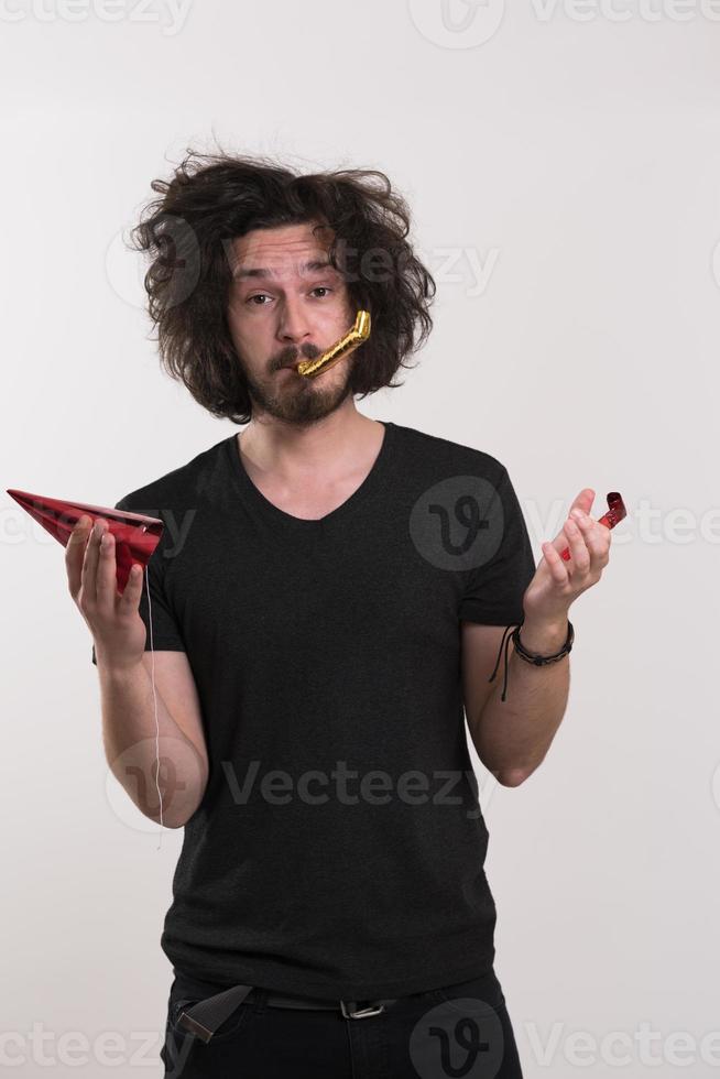 Portrait of a man in party hat blowing in whistle photo