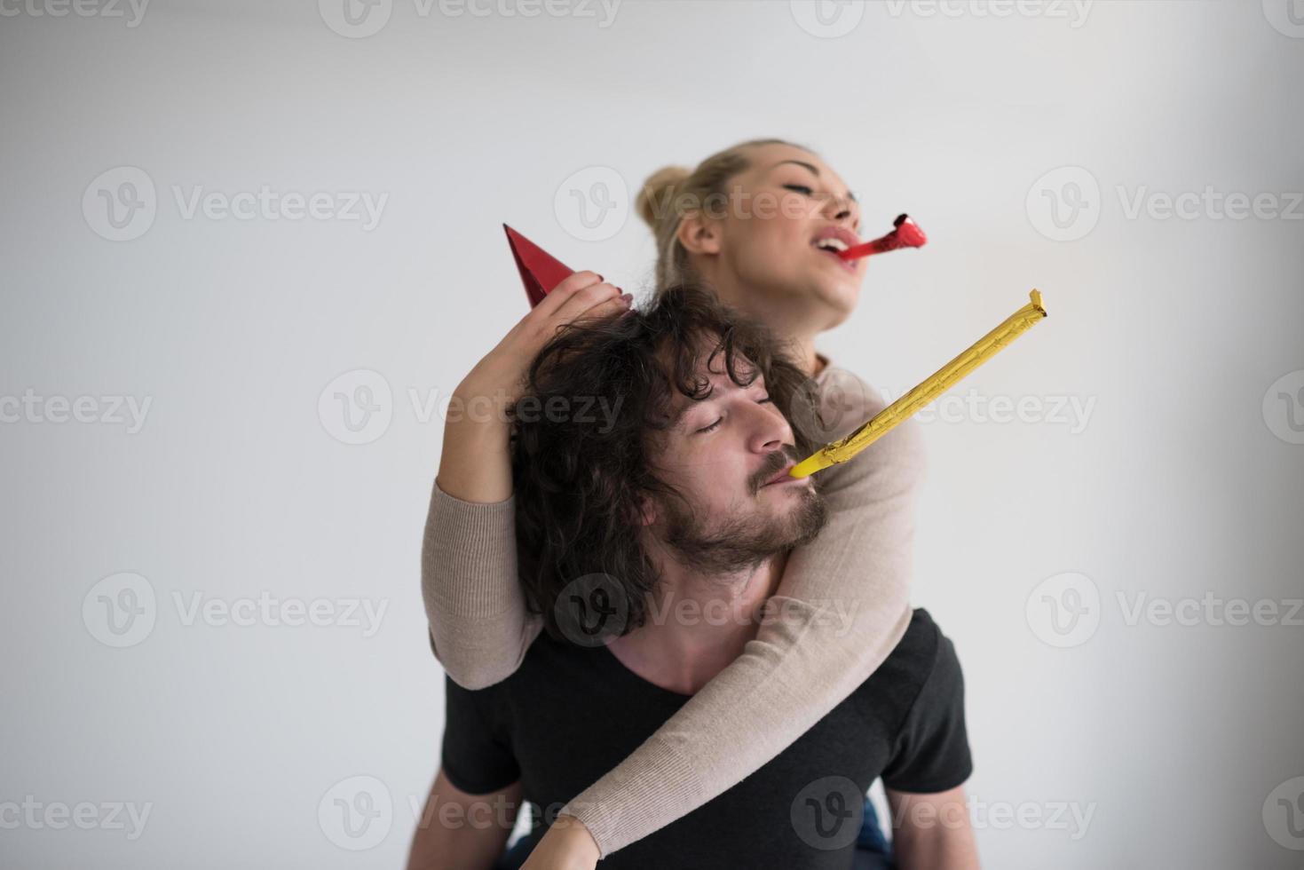 couple in party hats blowing in whistle photo