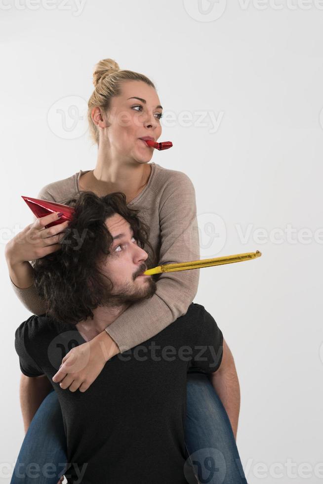 couple in party hats blowing in whistle photo