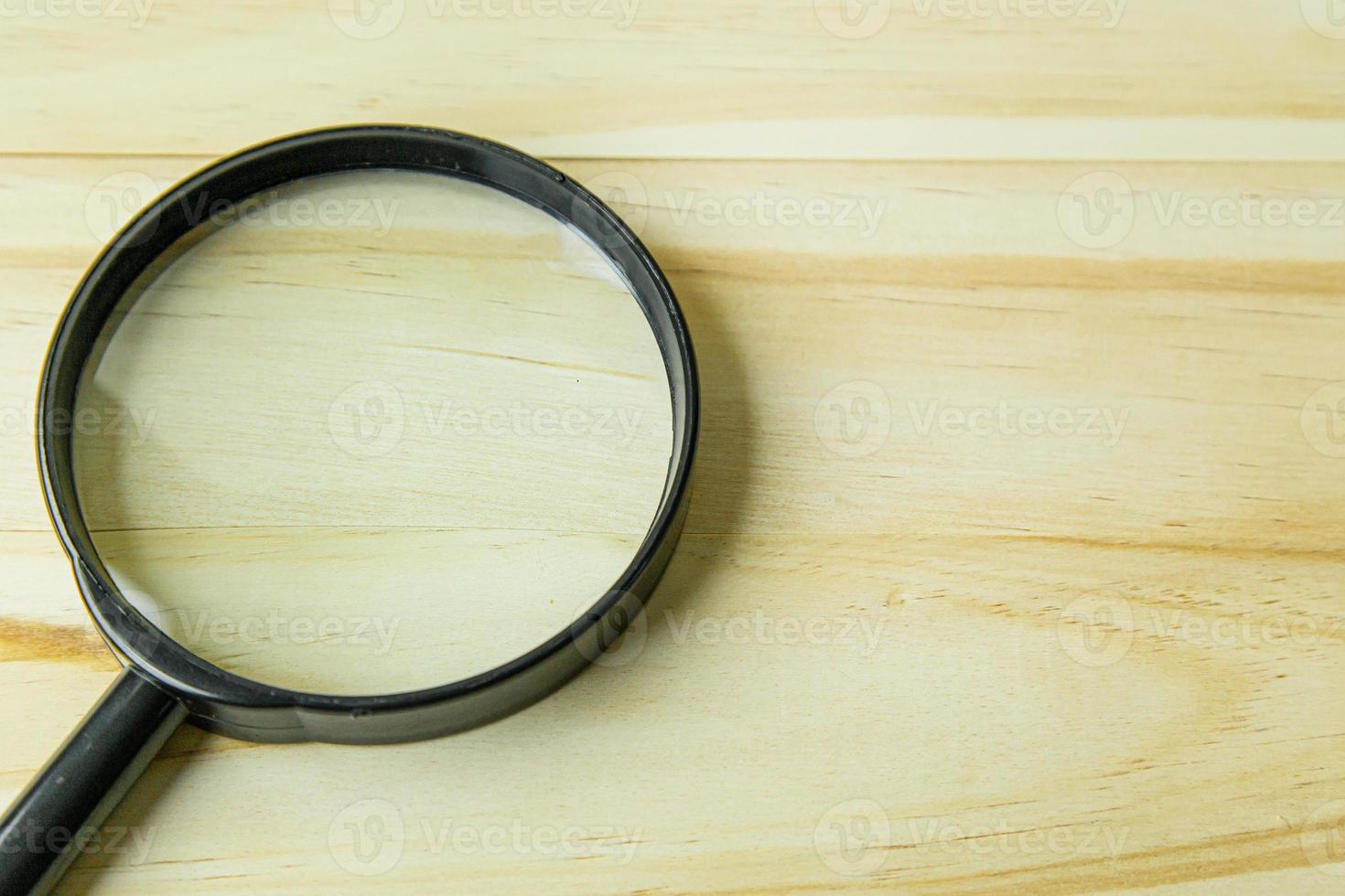 a  Magnifying glass on wood background image. photo