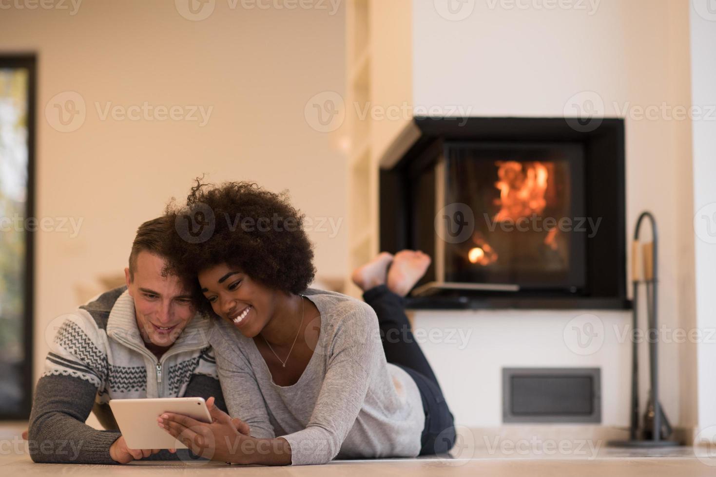 multiethnic couple using tablet computer on the floor photo