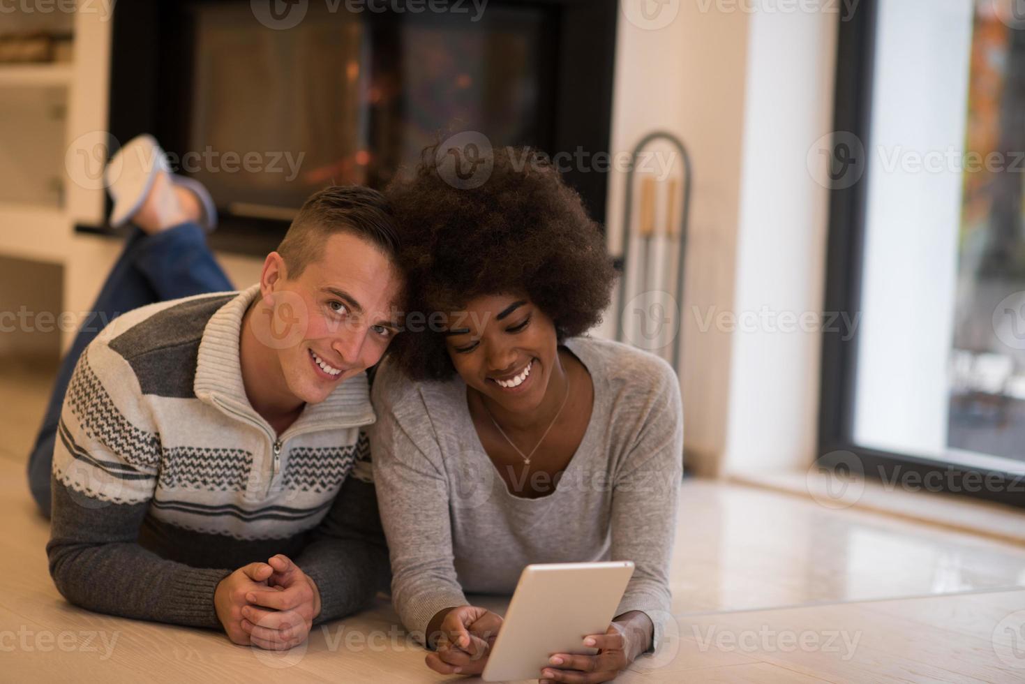 multiethnic couple using tablet computer on the floor photo