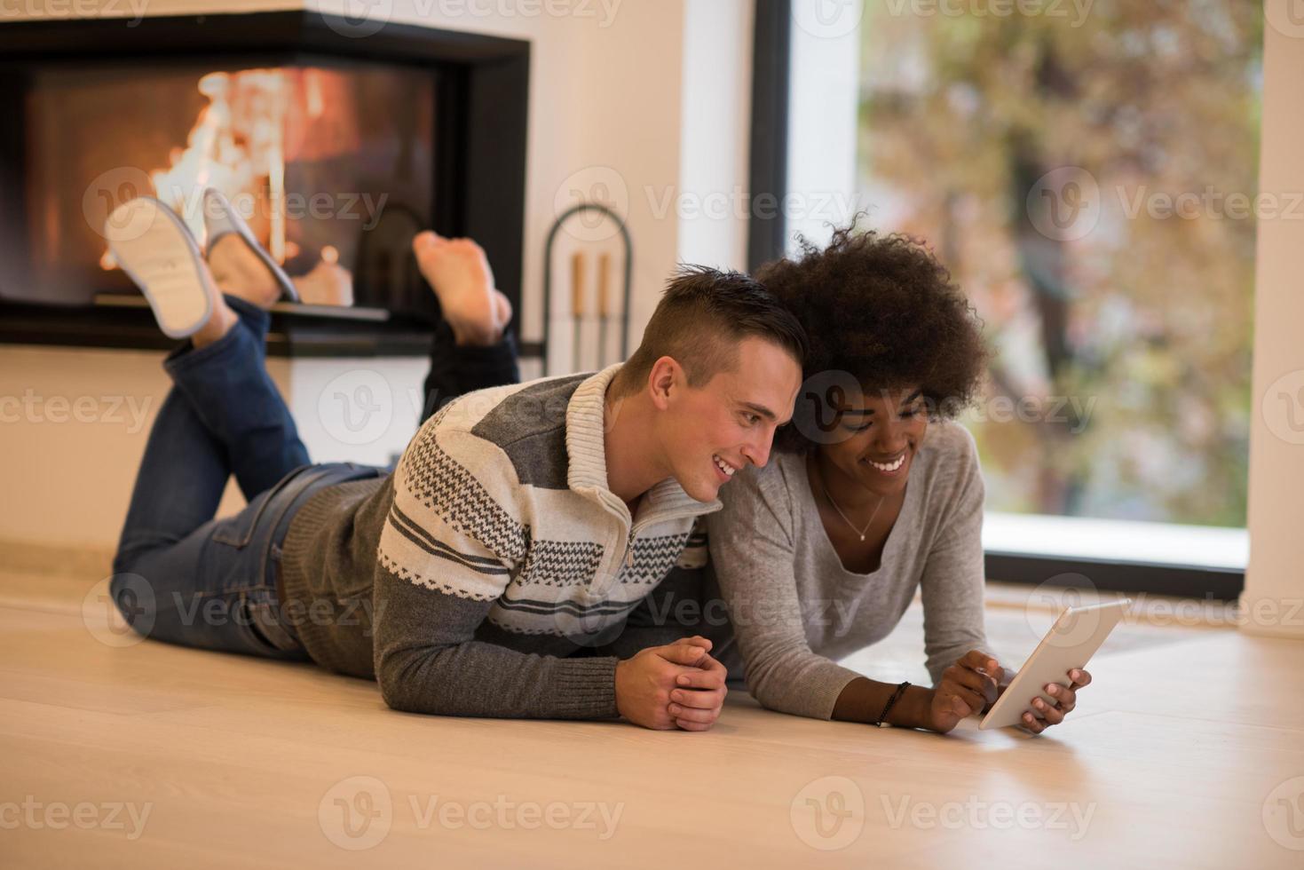 multiethnic couple using tablet computer on the floor photo
