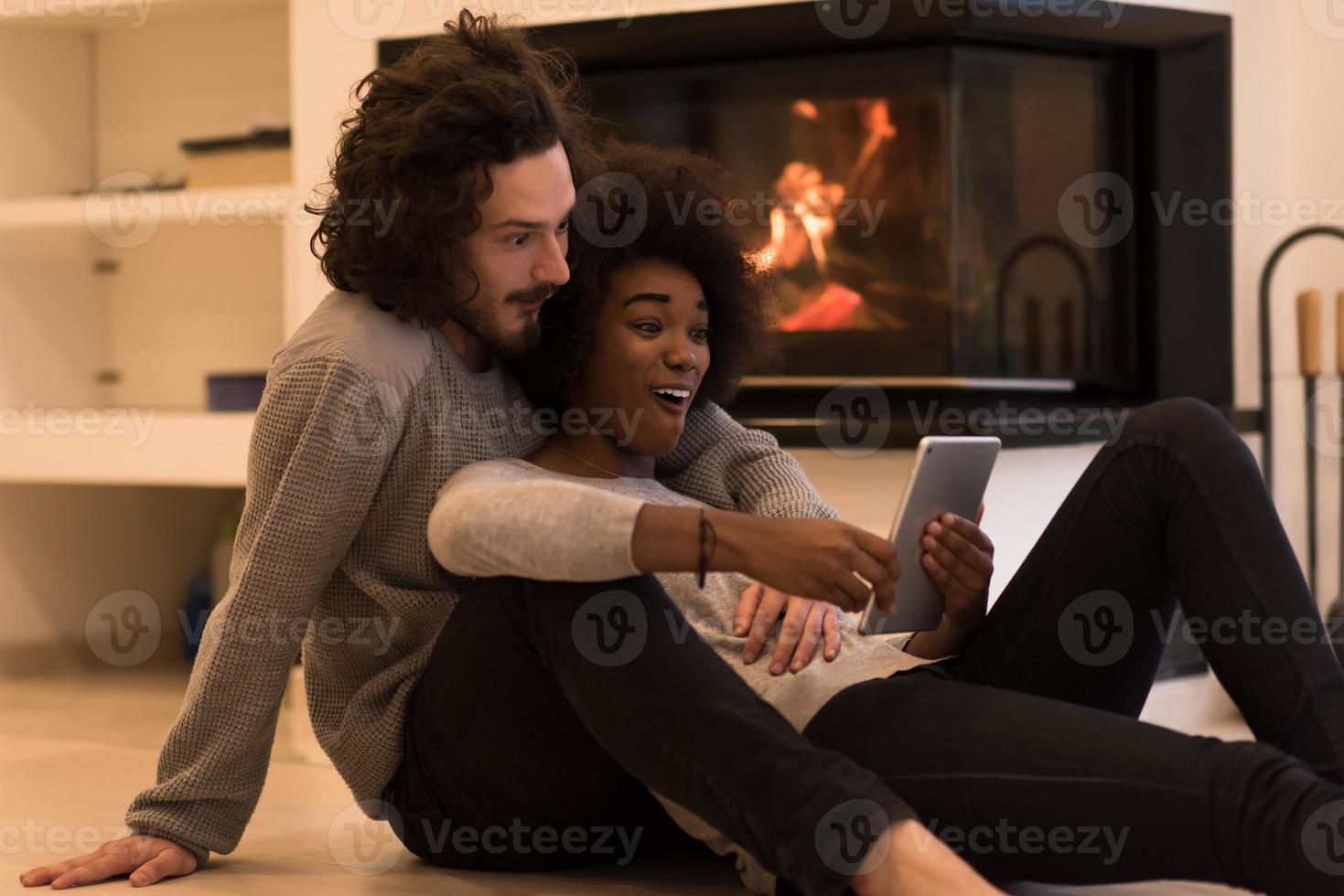 multiethnic couple using tablet computer on the floor photo