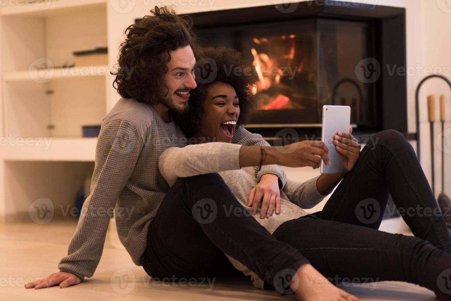 multiethnic couple using tablet computer on the floor photo