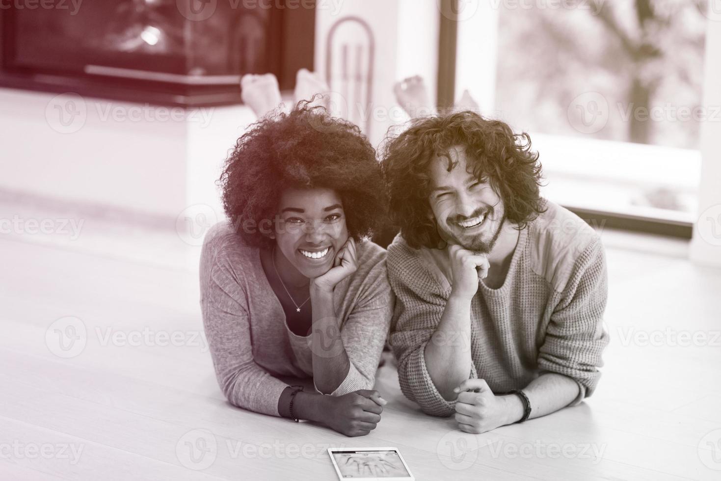 multiethnic couple used tablet computer on the floor photo