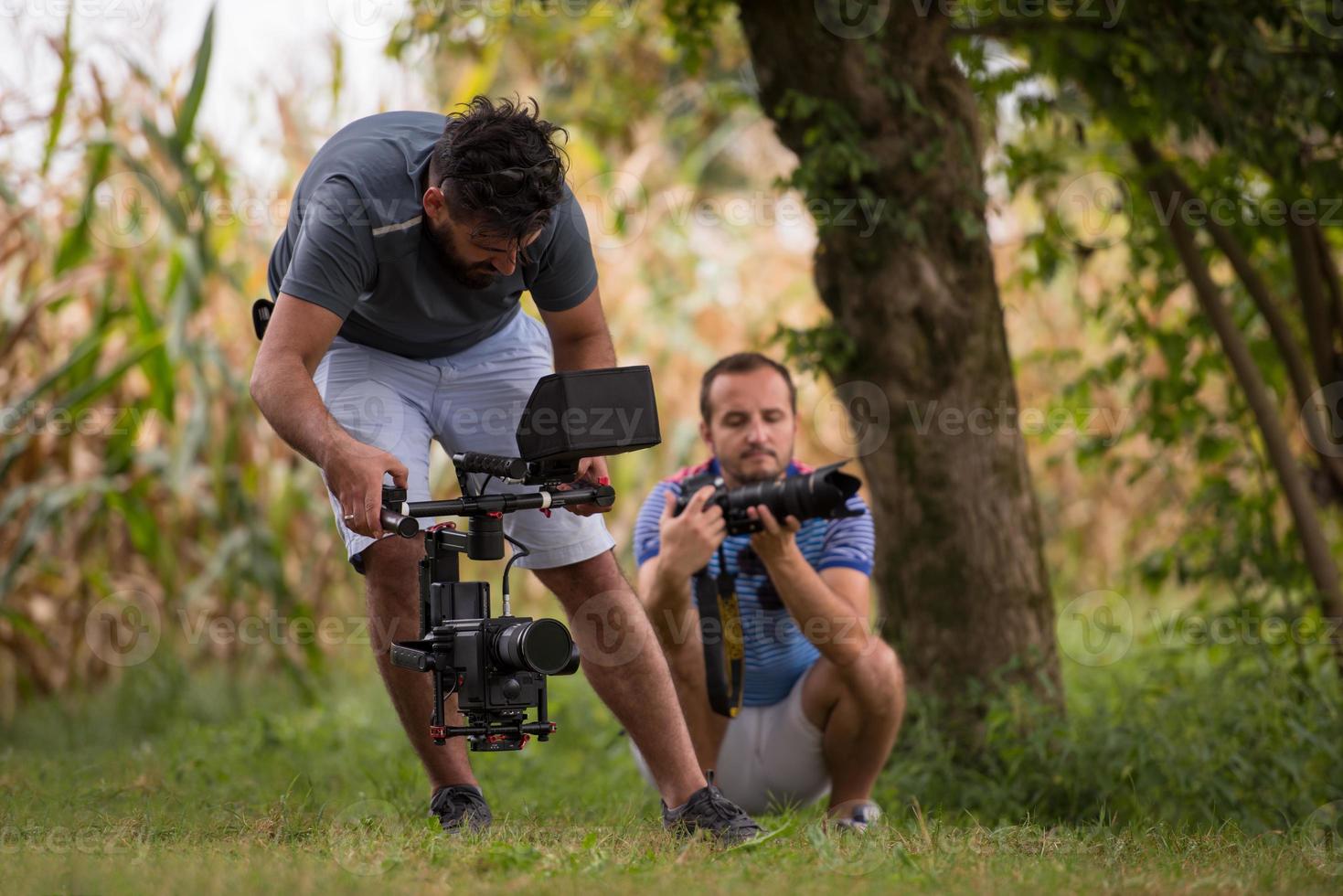 young videographer recording while woman doing yoga exercise photo