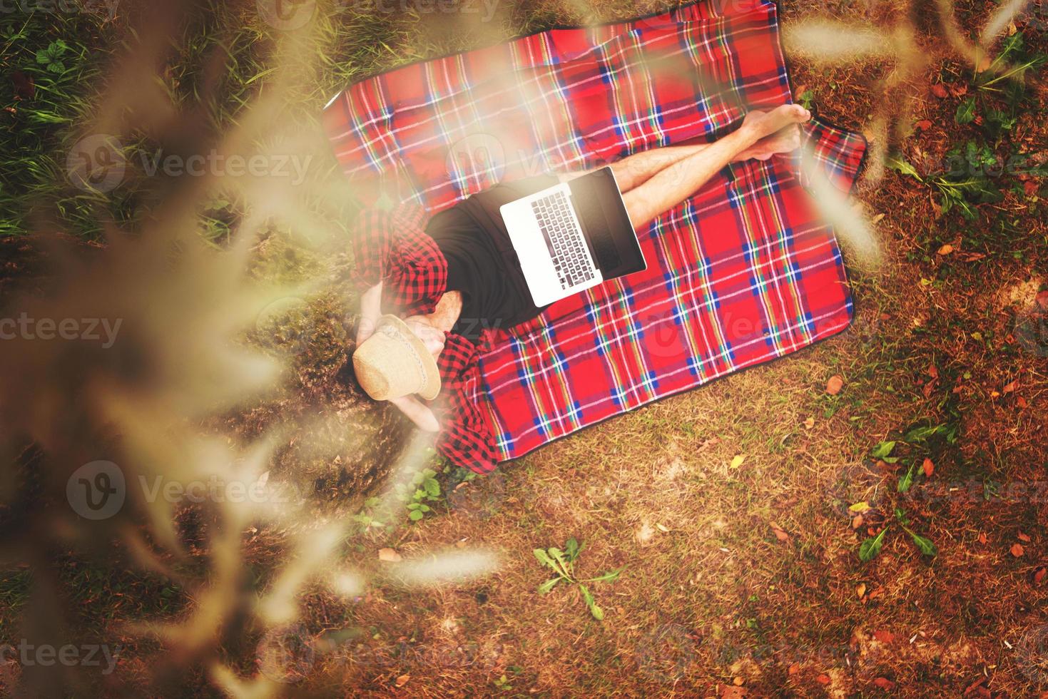 top view of man using a laptop computer under the tree photo