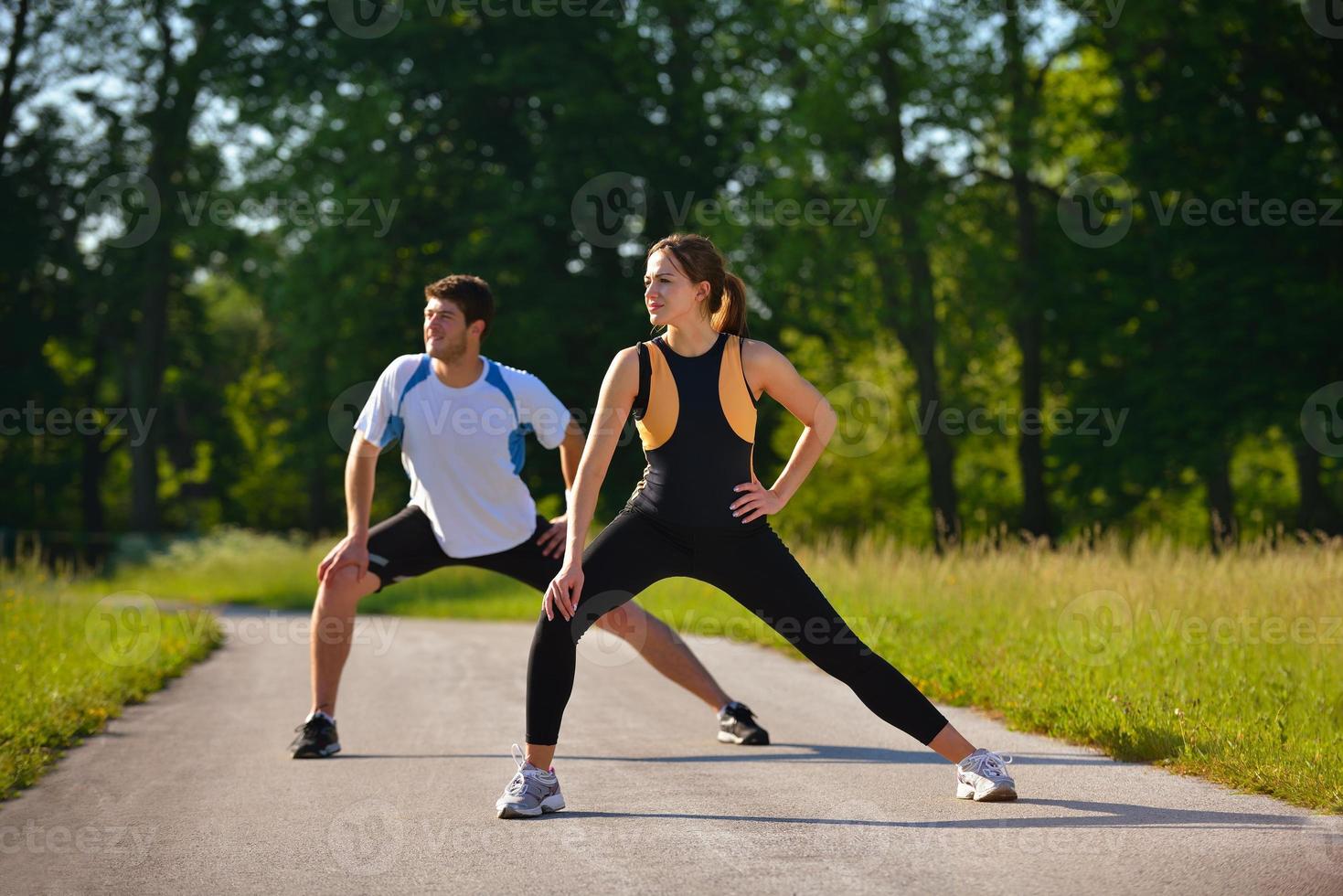 Couple doing stretching exercise  after jogging photo