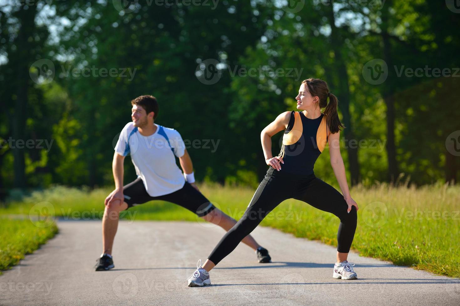 Couple doing stretching exercise  after jogging photo