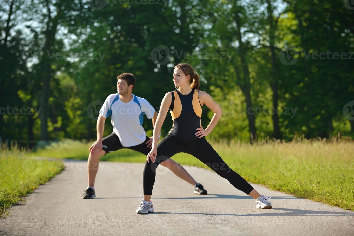 Couple doing stretching exercise  after jogging photo