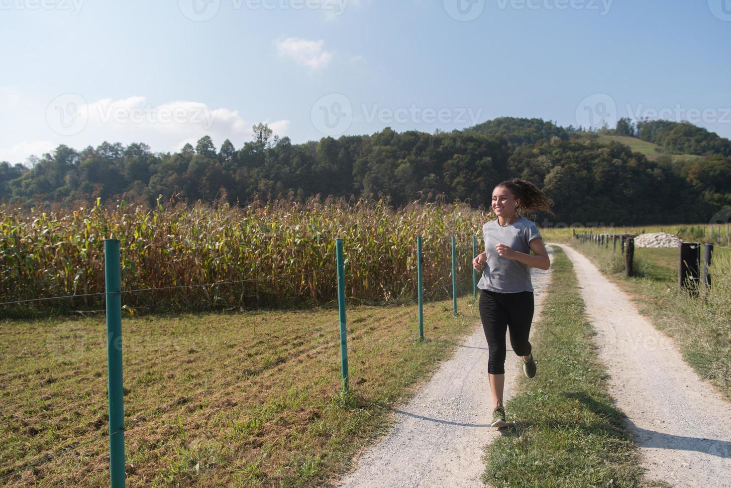 woman jogging along a country road photo