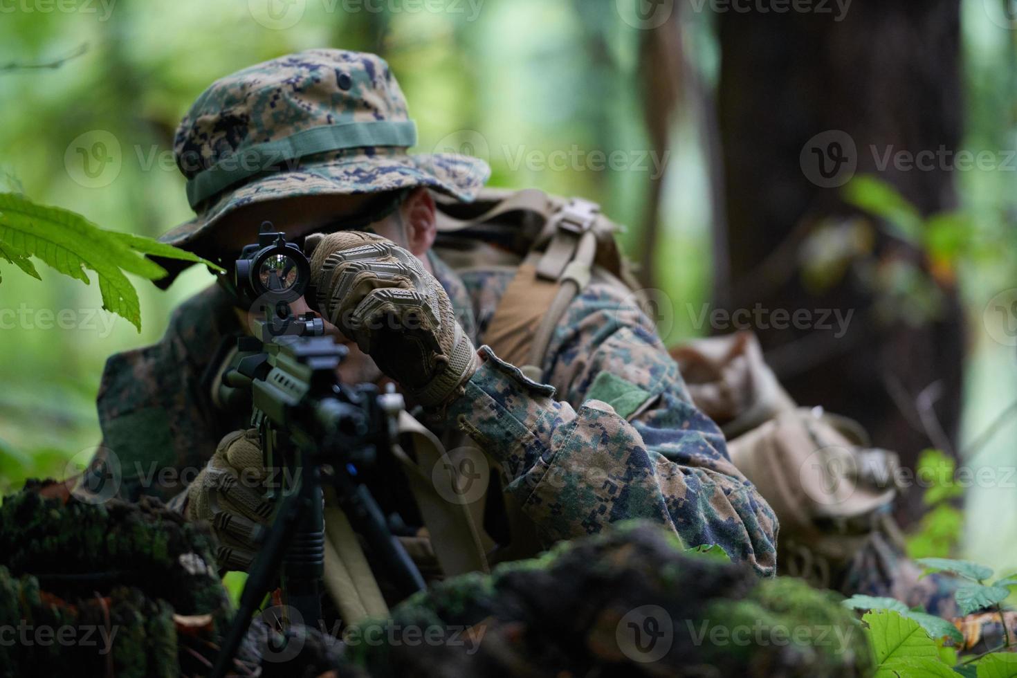 soldier in action aiming  on weapon  laser sight optics photo