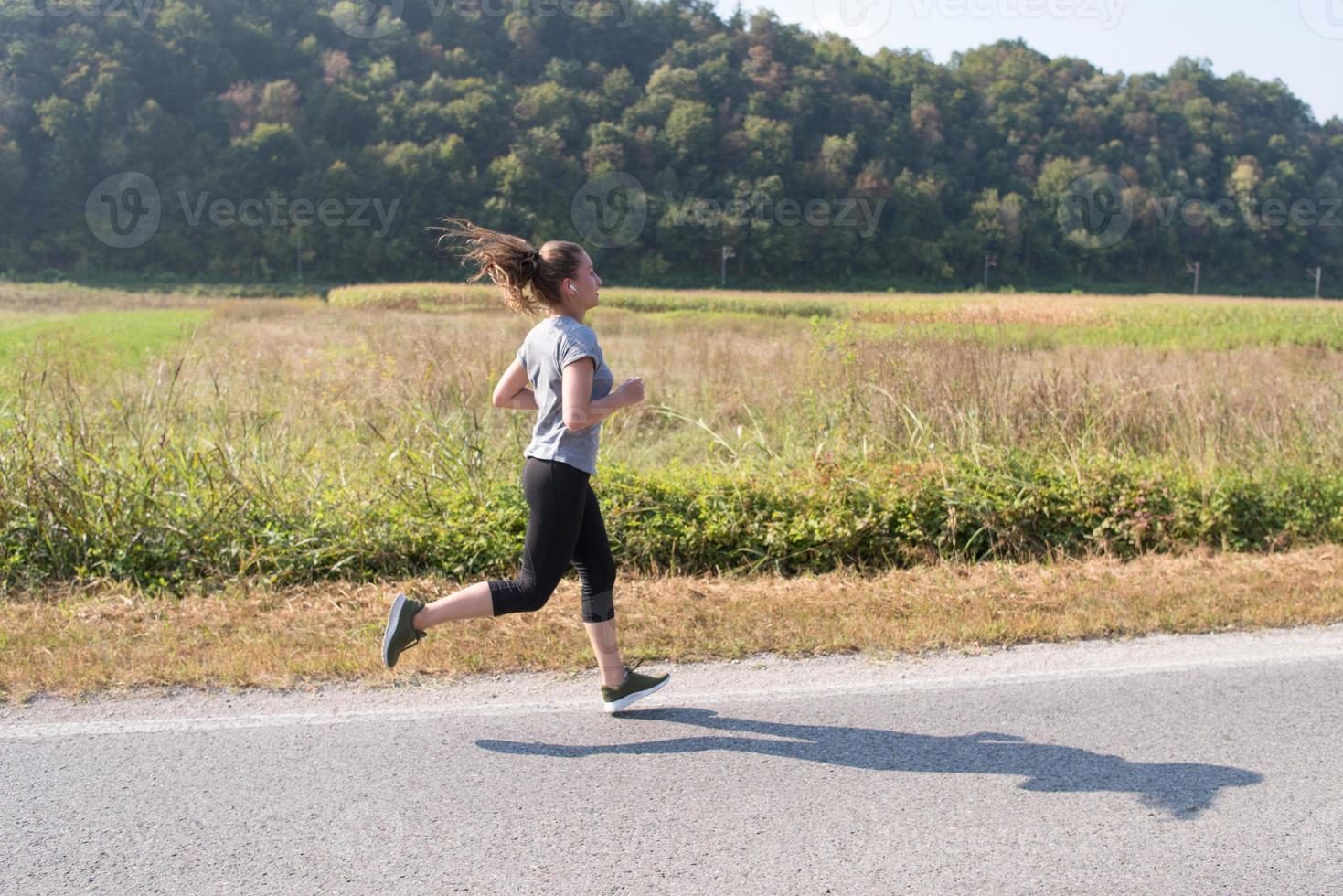 mujer corriendo por un camino rural foto
