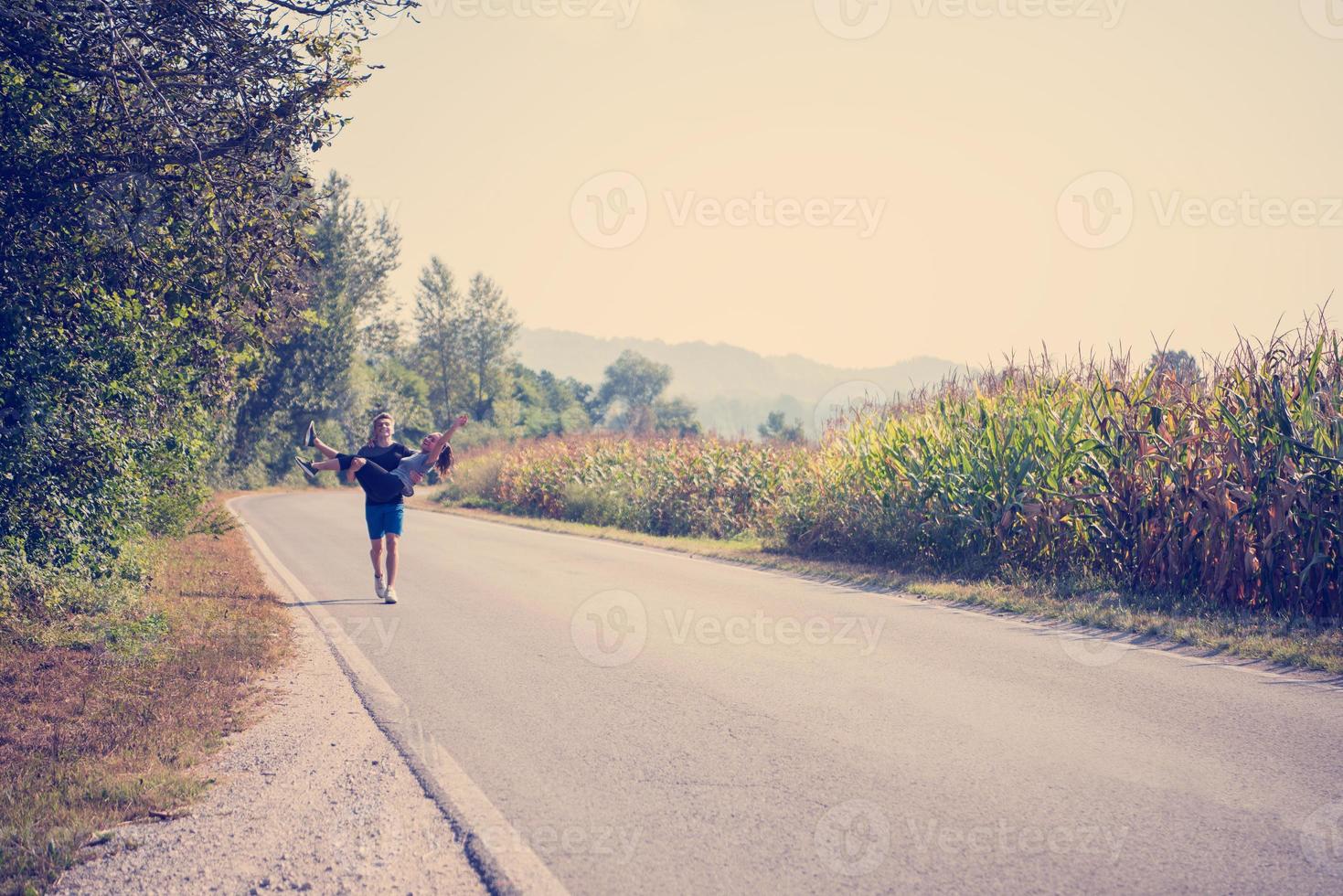 happy couple jogging along a country road photo